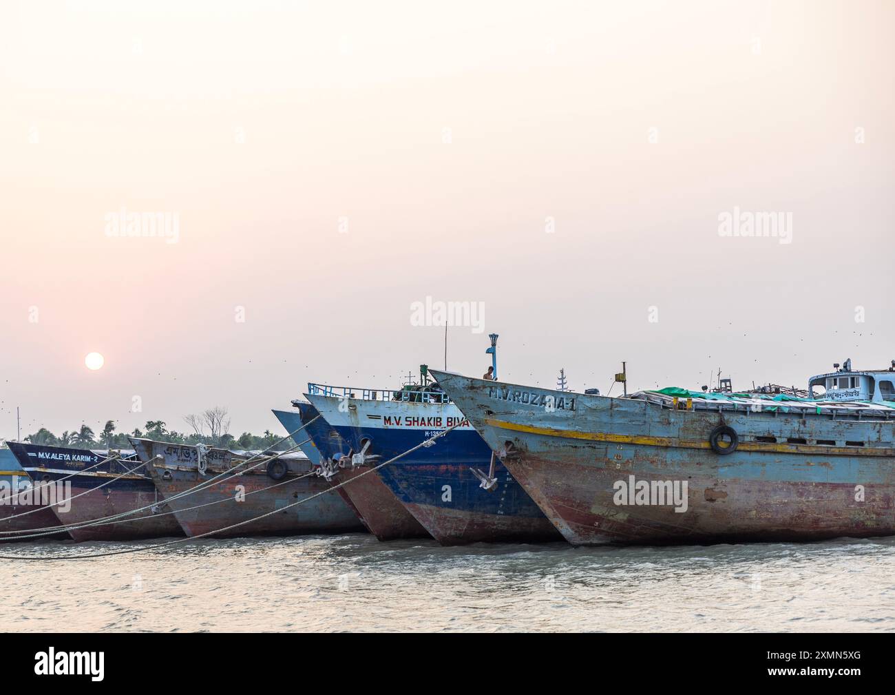 Pescherecci da traino ancorati al tramonto, divisione Khulna, Dacope, Bangladesh Foto Stock