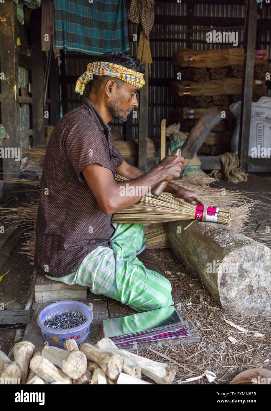 Bengalese che fa una scopa nel suo laboratorio a Sundarbans, Barisal Division, Harta, Bangladesh Foto Stock