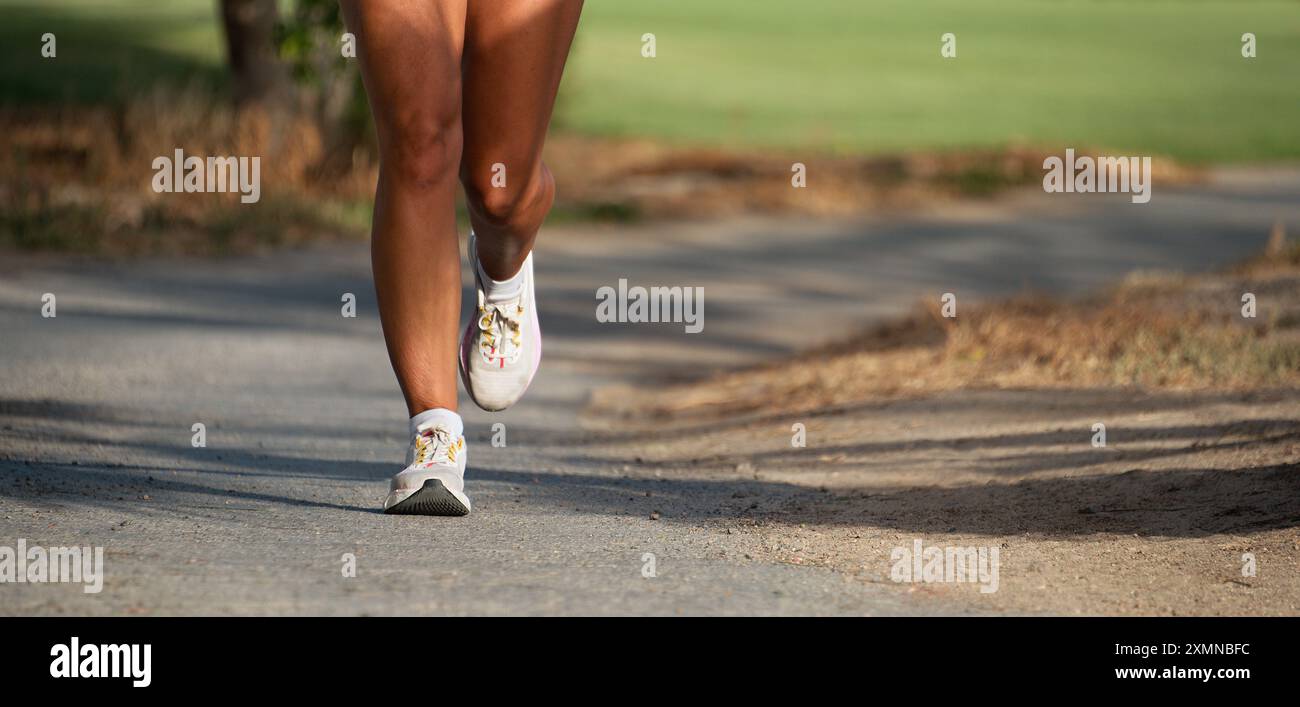 Giovane donna fitness gambe, corsa nel parco pubblico della città di mattina Foto Stock