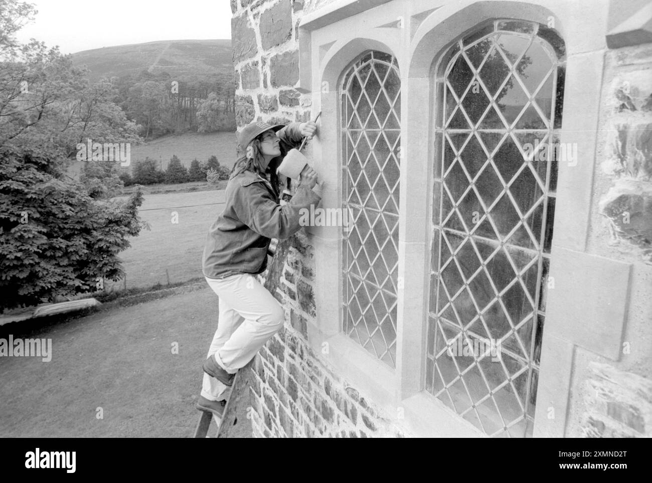 Stonemason , Jenny Cox , 28 , di Wells , Somerset , uno dei pochi scalpellini femminili in Gran Bretagna , mette il tocco finale ad una finestra di sette piedi che ha scolpito per la famosa chiesa di Oare , su Exmoor , dove Lorna Doone è stata uccisa il giorno del suo matrimonio. La finestra , nella torre della chiesa , sostituisce quella gravemente danneggiata nelle tempeste invernali. 14 giugno 1991 foto di Roger Bamber Foto Stock