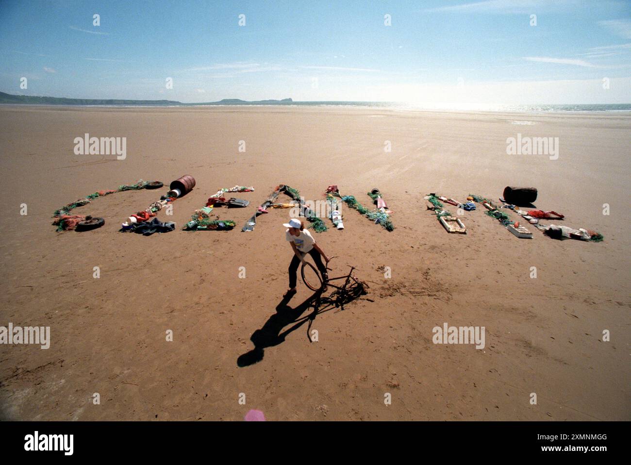 Susannah Hickling , Readers Digest Environment Editor scrive un semplice messaggio ' Pulisci me' dai rifiuti raccolti in 500 metri di una delle 250 spiagge che i volontari stanno prendendo di mira per il lancio della campagna 'Beachwatch '98' Clean Beach . Lo scorso anno oltre 2.400 volontari hanno raccolto un totale di 262.349 rifiuti, tra cui 4.243 lunghezze di rete da pesca, 8064 lattine per bevande, 1.153 contenitori per olio e detergente e 17.053 confezioni croccanti e dolci. Il cartello "Clean Beach" è composto da vecchie biciclette, reti da pesca, fusti d'olio, pneumatici per auto, bottiglie di plastica, uccelli morti, lattine di vernice e una varietà di scarti Foto Stock