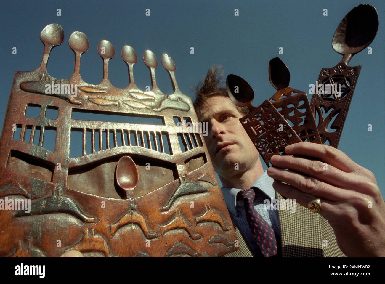 Un banditore ispeziona antichi cucchiai d'amore gallesi in vendita presso la casa d'aste Sothebys a Billingshurst West SussexPicture di Roger Bamber Foto Stock