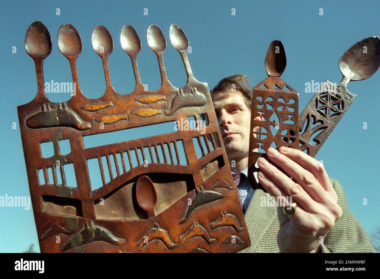 Un banditore ispeziona antichi cucchiai d'amore gallesi in vendita presso la casa d'aste Sothebys a Billingshurst West SussexPicture di Roger Bamber Foto Stock