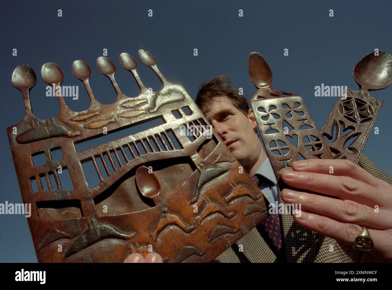 Un banditore ispeziona antichi cucchiai d'amore gallesi in vendita presso la casa d'aste Sothebys a Billingshurst West SussexPicture di Roger Bamber Foto Stock