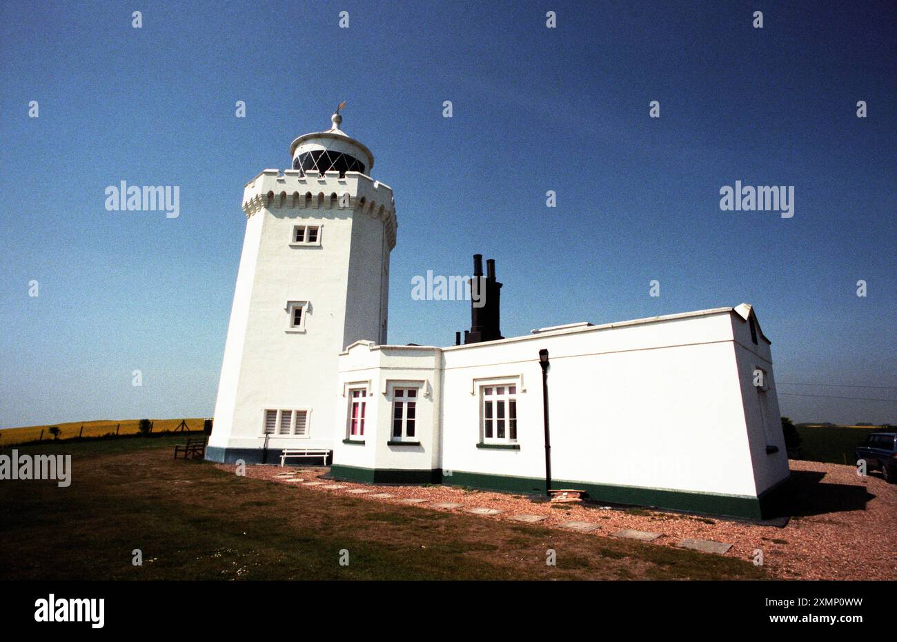 Foto di Roger Bamber: 2 maggio 1997: Una bandiera dell'unione vola accanto al faro di South Foreland sopra le bianche scogliere di dover, Kent, Inghilterra, Regno Unito. Fotografia di paesaggi, viaggi, cieli blu, architettura. Foto Stock