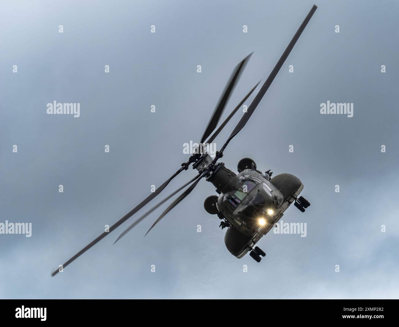Il RAF Chinook display Team nel suo Boeing CH-47 Chinook si esibisce contro un cielo nuvoloso al RIAT 2024 Foto Stock