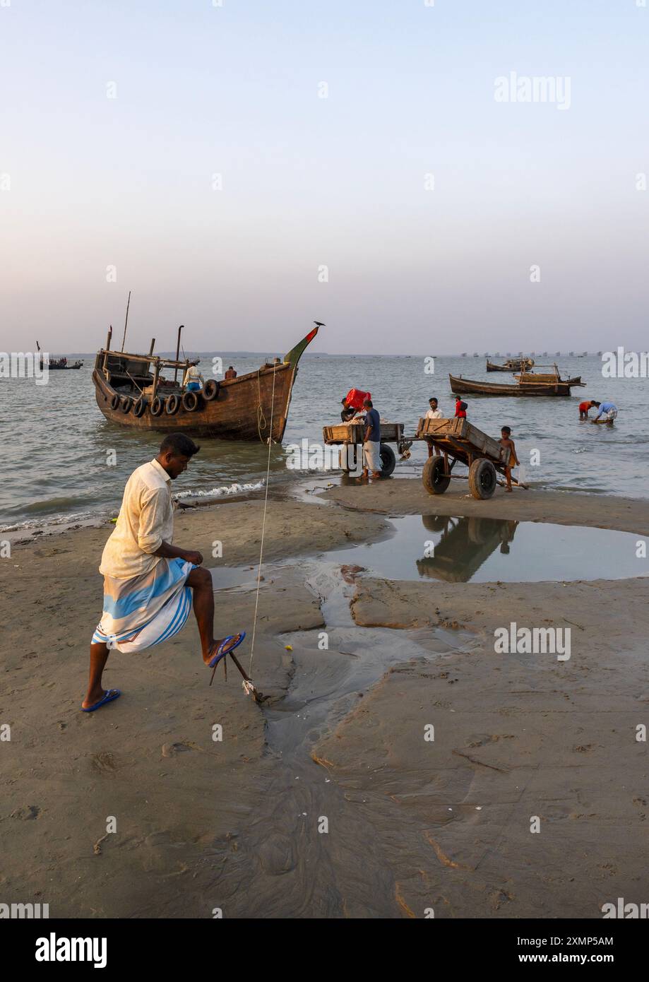 Pescatori del Bangladesh che scaricano pesci sulla spiaggia, divisione Chittagong, Cox's Bazar Sadar, Bangladesh Foto Stock