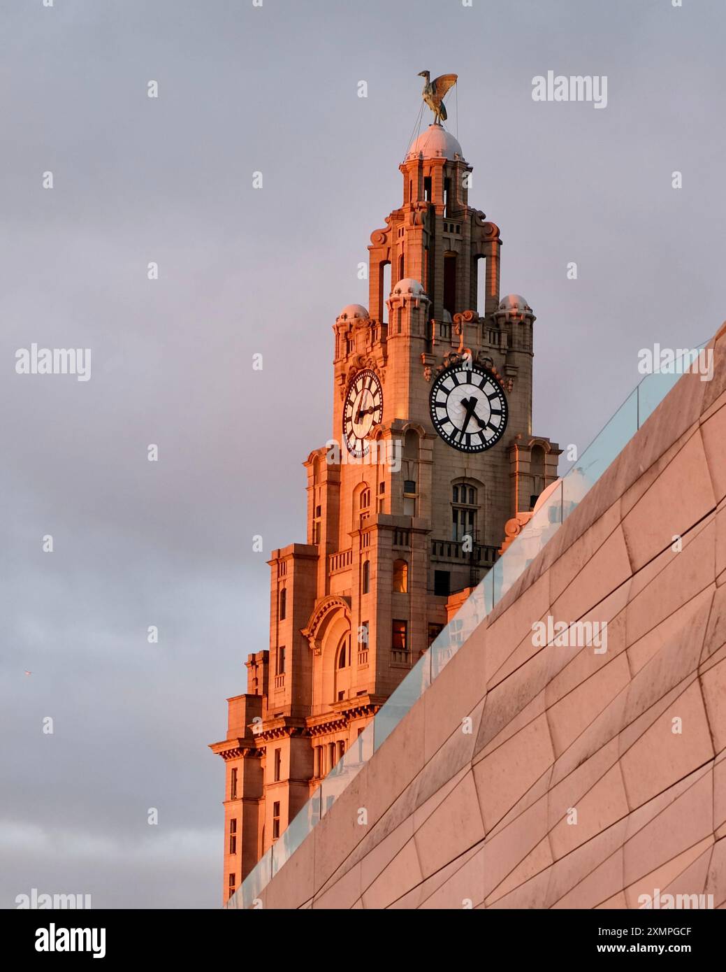 Un'immagine di una torre dell'orologio del Liver Building a Liverpool sotto la luce dorata al tramonto Foto Stock