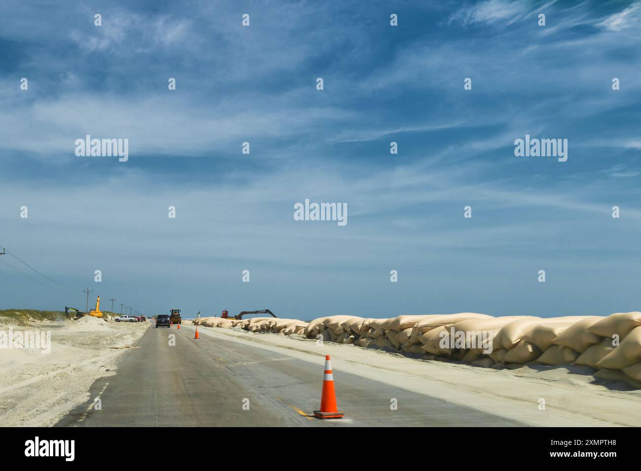 Ocracoke Island, Outer Banks, North Carolina, USA - 16 aprile 2024: Tratto da un'auto in movimento, prevenzione dell'erosione e pulizia della strada delle settimane precedenti Foto Stock