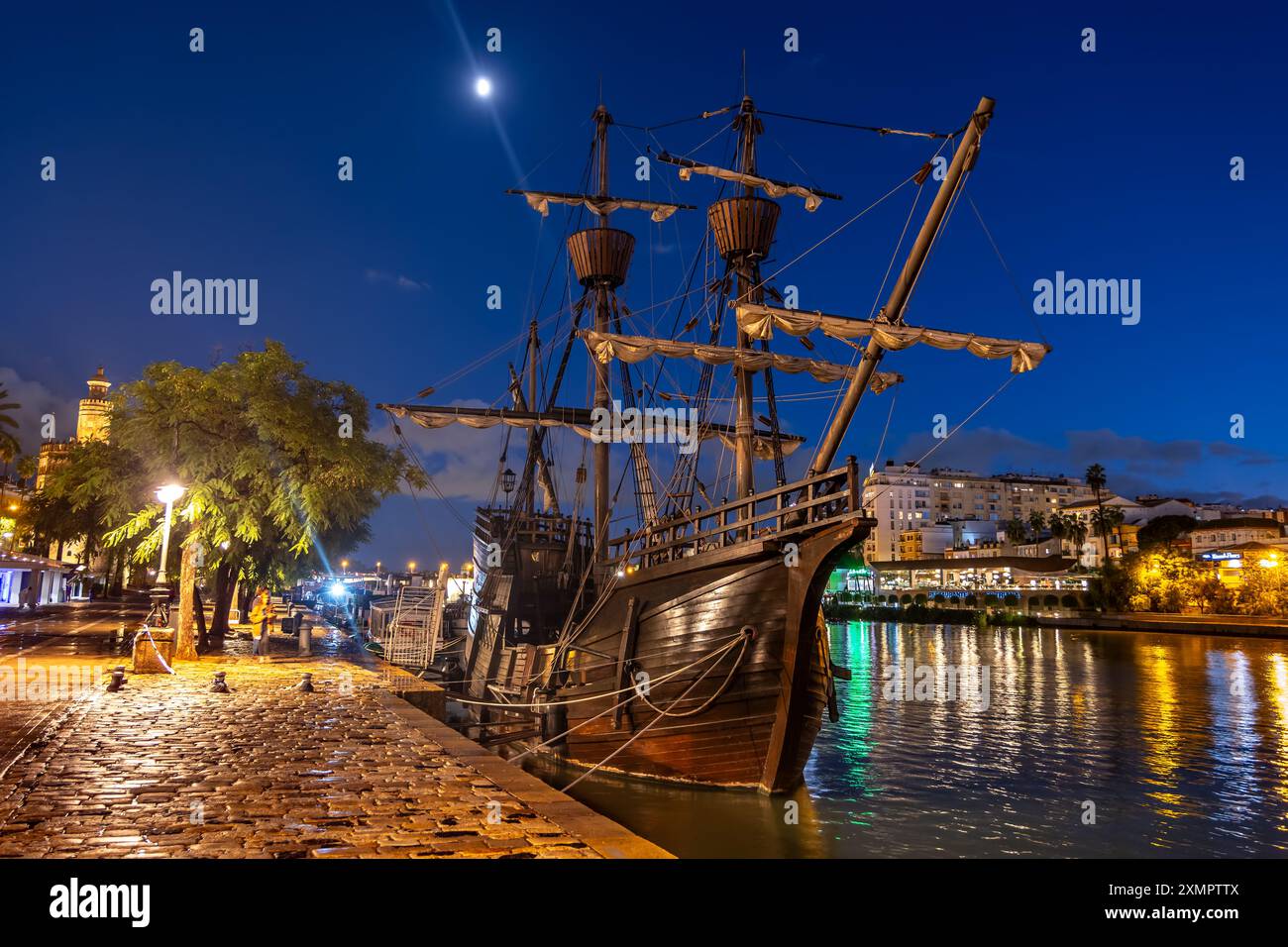 Nave a vela NAO Victoria Carrack replica di notte, ormeggiata sul lungomare di Siviglia, Spagna. Storica nave spagnola che fece la prima circumnavi Foto Stock