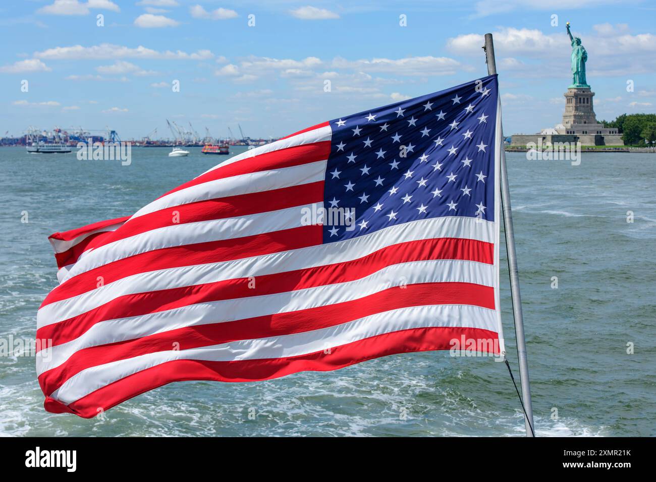 The Stars & Stripes sulla poppa di una delle barche da crociera che portano i turisti alle Liberty e Ellis Islands nel porto di New York, Stati Uniti. Foto Stock
