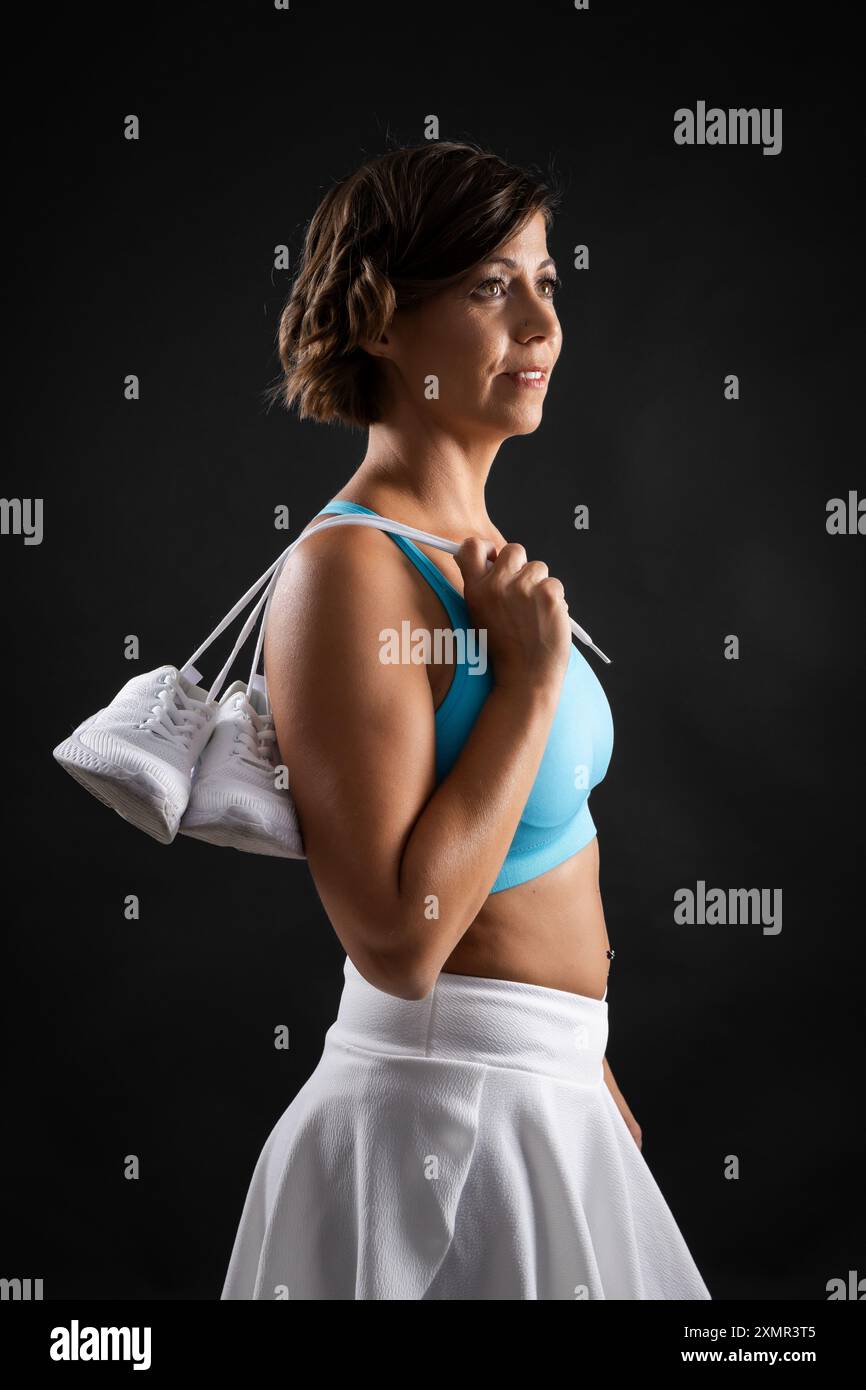 Vesti la donna caucasica con taglio di capelli in posa in studio indossando abiti da palestra Foto Stock