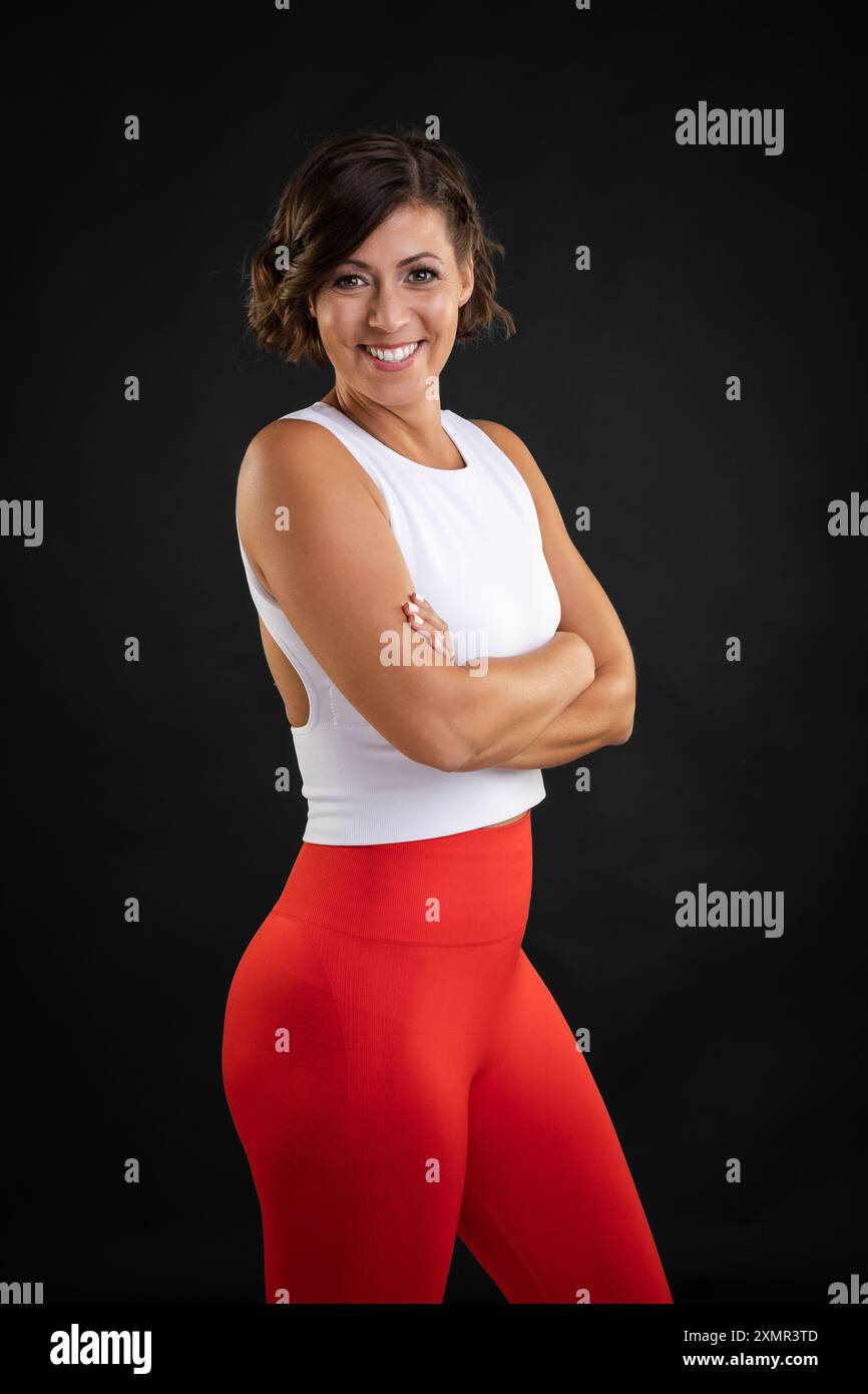 Vesti la donna caucasica con taglio di capelli in posa in studio indossando abiti da palestra Foto Stock