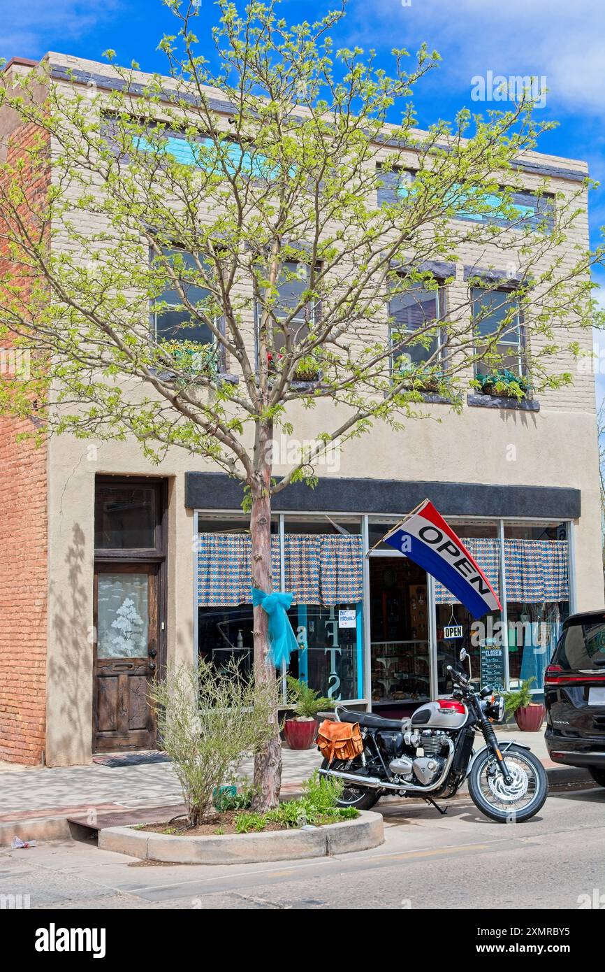 La Triumph ha parcheggiato prima del negozio di articoli da regalo nell'edificio commerciale 1920 nel centro di Winslow, Arizona, aprile 2024 Foto Stock