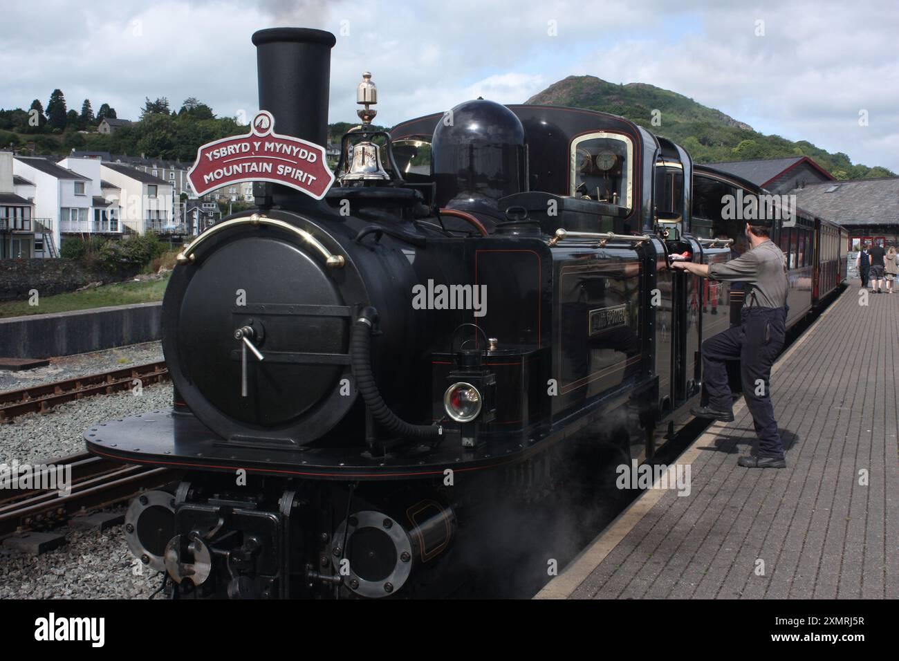 La locomotiva a vapore Mountain Spirit sta per trasportare un lungo treno per Blaenau Ffestiniog a Snowdonia dalla stazione di Porthmadog Foto Stock