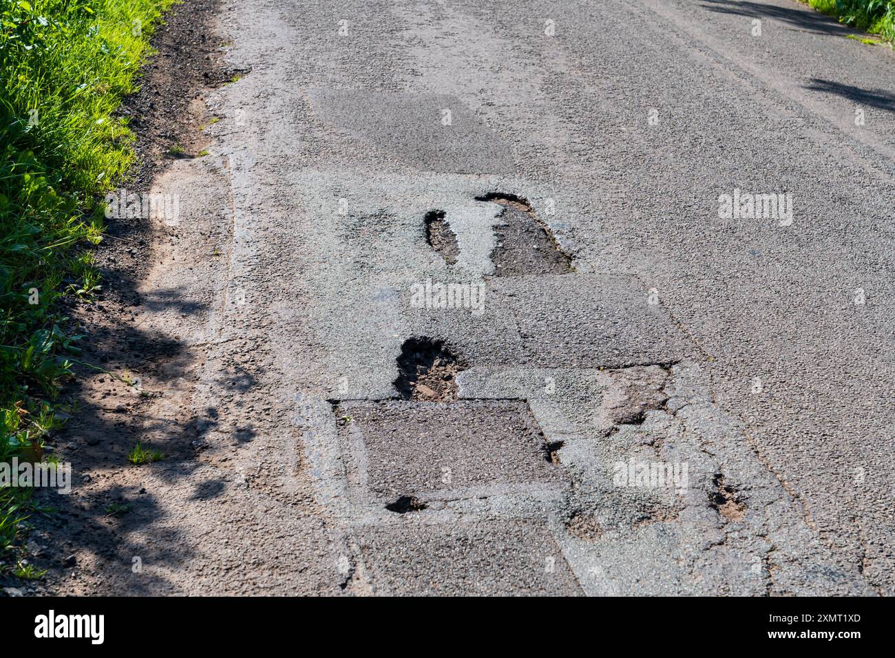 Buche su una strada del Regno Unito, danni da Pothole Foto Stock