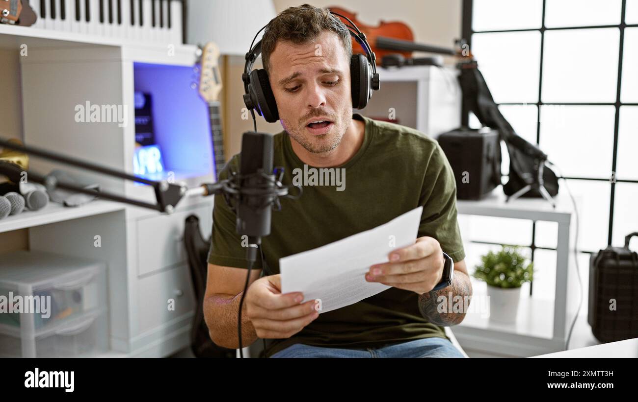 Uomo ispanico che canta in studio musicale con microfono e cuffie Foto Stock