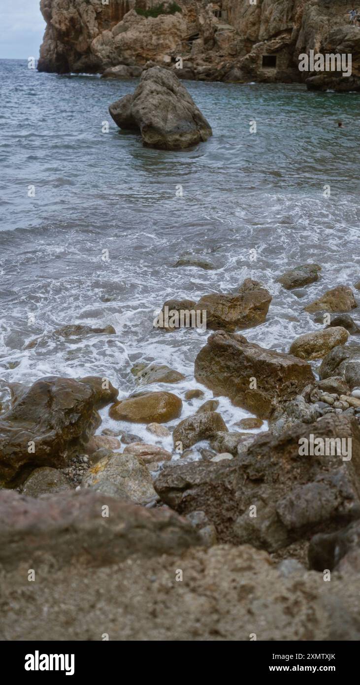 Mare mediterraneo con coste rocciose e acque cristalline a cala deia, maiorca, spagna, catturando tranquille scene della natura. Foto Stock