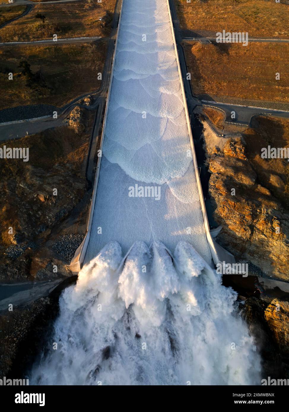 Vista aerea della nuova diga del lago Oroville in azione che scarica l'acqua nel fiume Feather sottostante Foto Stock