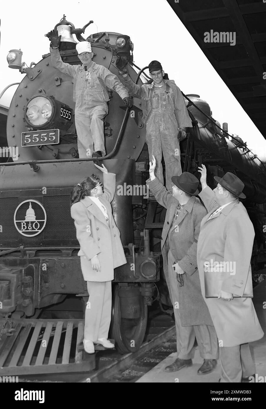 Gli ingegneri ferroviari saltano verso i passeggeri in partenza dalla loro locomotiva in una fotografia di allestimento a Chicago, CA. 1946. Foto Stock