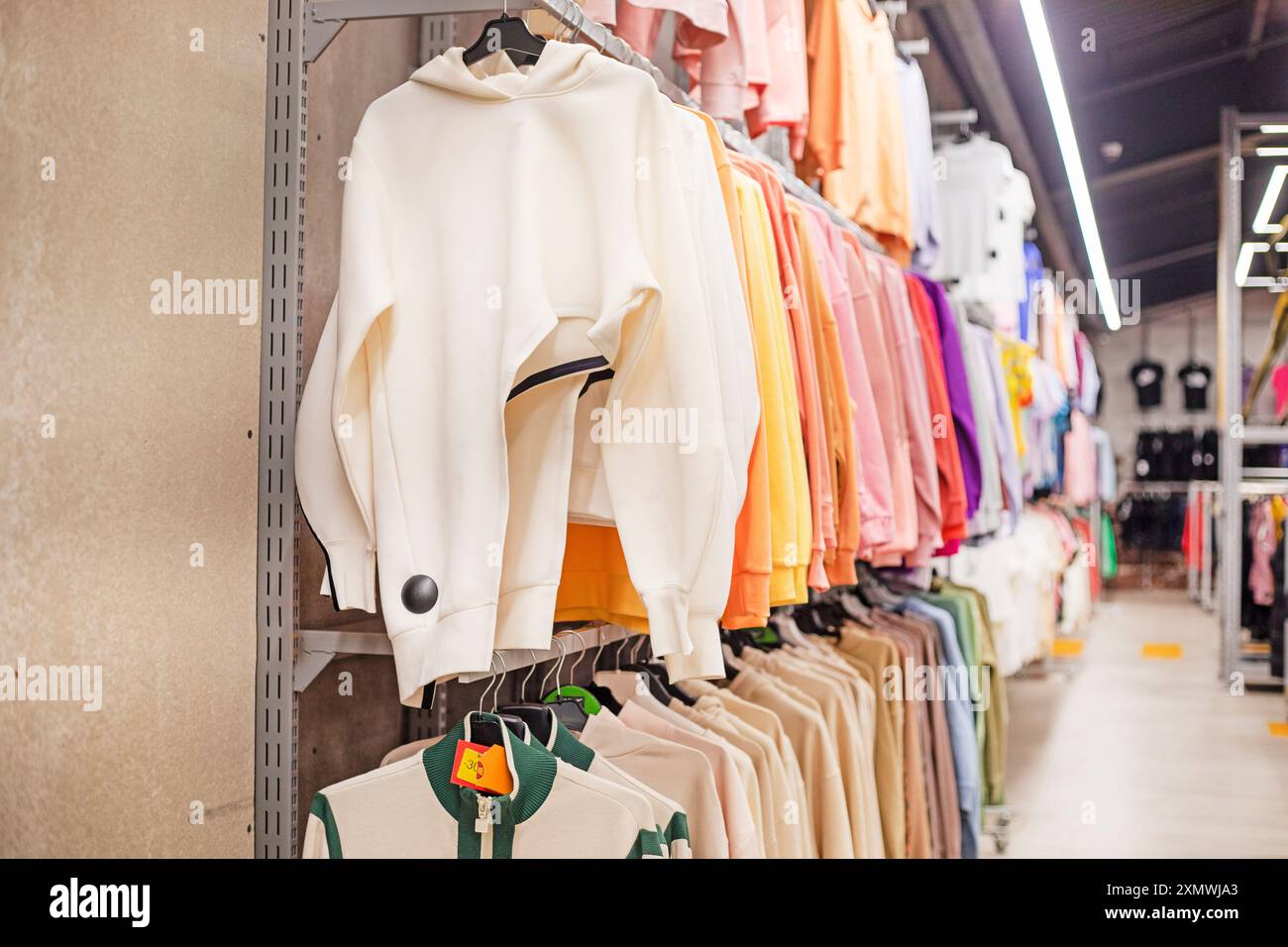 felpa sportiva multicolore da donna nel reparto sportivo del supermercato. Vita di tutti i giorni, stile casual Foto Stock