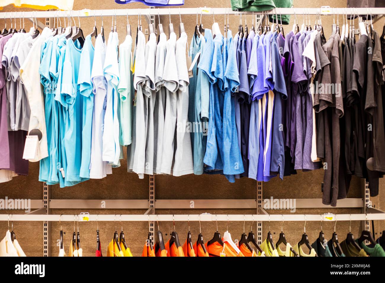 Magliette sportive da uomo multicolore e felpe nel reparto sportivo del supermercato. Vita di tutti i giorni, stile casual Foto Stock