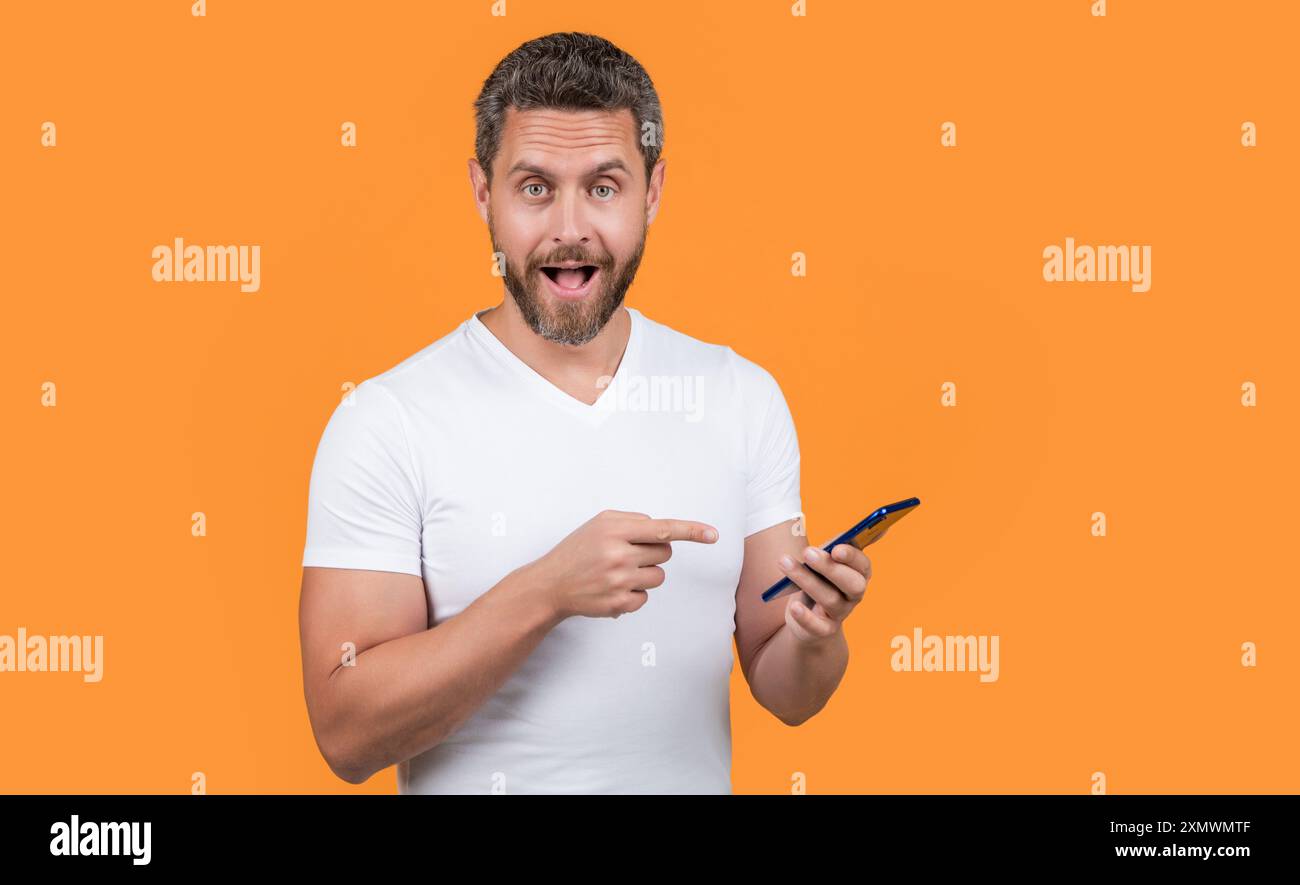 un uomo stupito controlla la chat di comunicazione con lo smartphone. concetto di comunicazione. Foto Stock