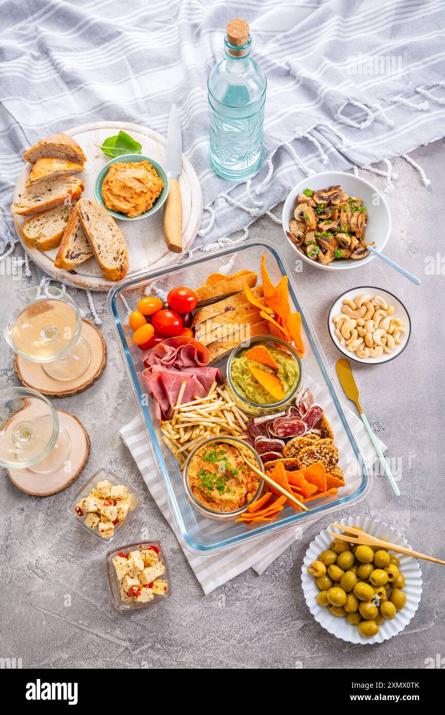 Vassoio con antipasti e vino per un picnic e per mangiare all'aperto Foto Stock