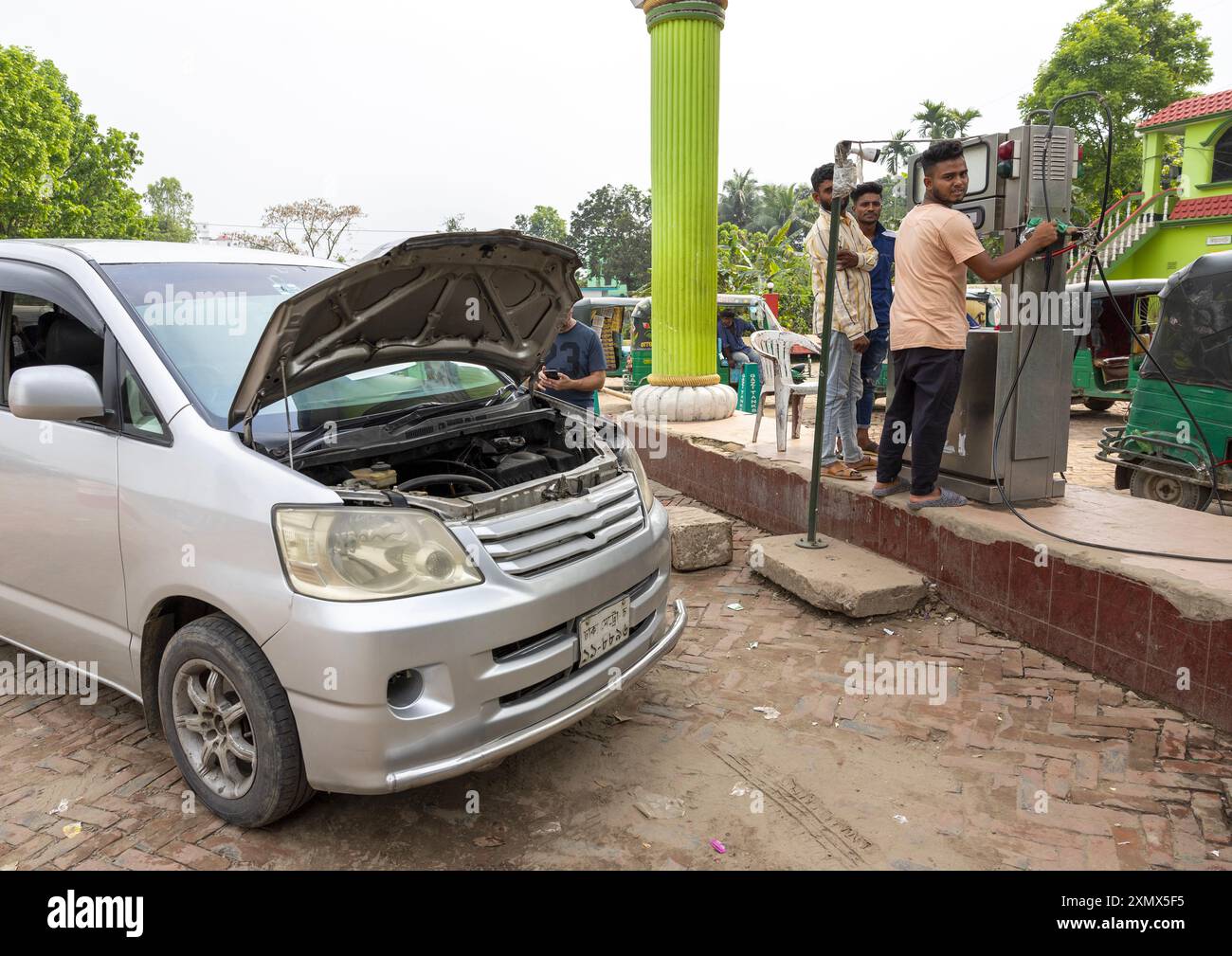 Un'auto viene alimentata con gas naturale compresso in una stazione di pompaggio, Chittagong Division, Ashuganj, Bangladesh Foto Stock