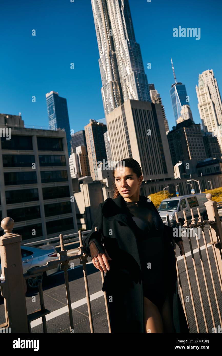 Una giovane donna fa una pausa in una strada di New York, il suo sguardo fisso sul lontano paesaggio urbano. Foto Stock