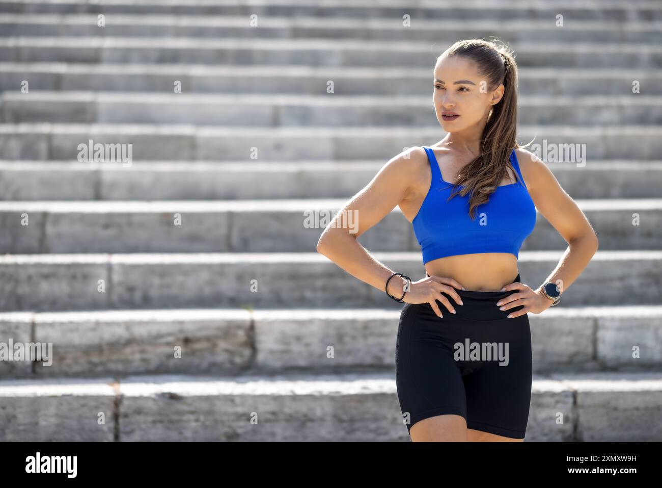 Foto di una giovane donna attraente che fa una pausa durante l'allenamento nel parco. Foto Stock