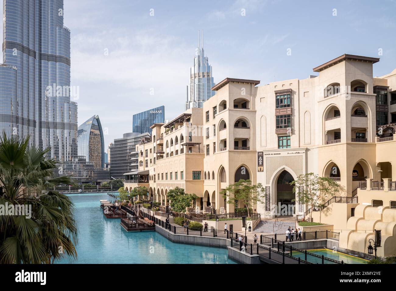 Dubai, UAE – Passeggiata sul lungomare e architettura tradizionale del Souk Al Bahar nel centro di Dubai, con il Burj Khalifa che si erge sopra lo skyline della città moderna Foto Stock