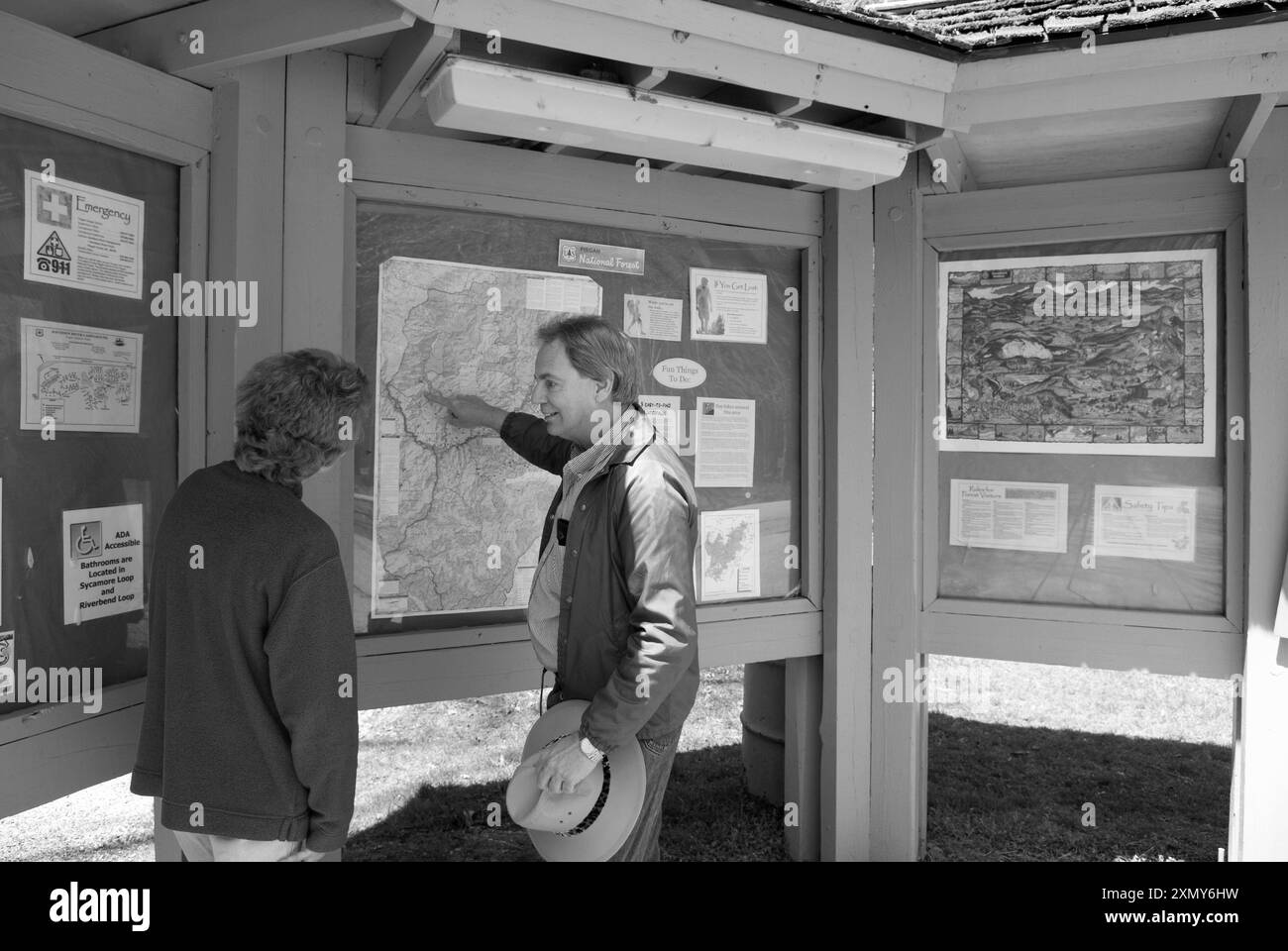 Coppia caucasica matura che legge una cartina all'inizio di un sentiero nel Davidson River Campground, Brevard, North Carolina, USA. Foto Stock