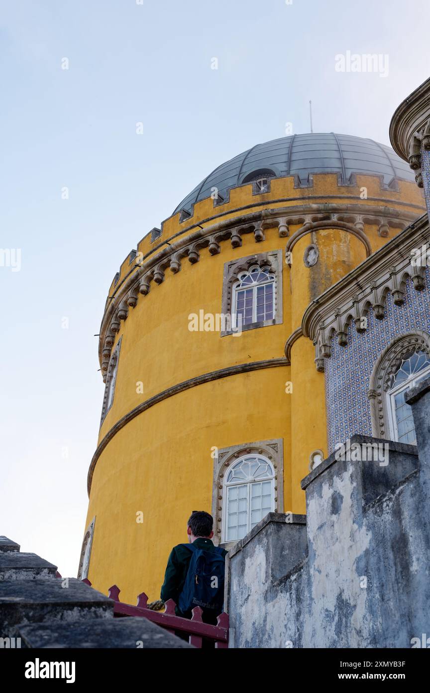 Un visitatore osserva la vibrante torre gialla a cupola del Palácio da pena Foto Stock