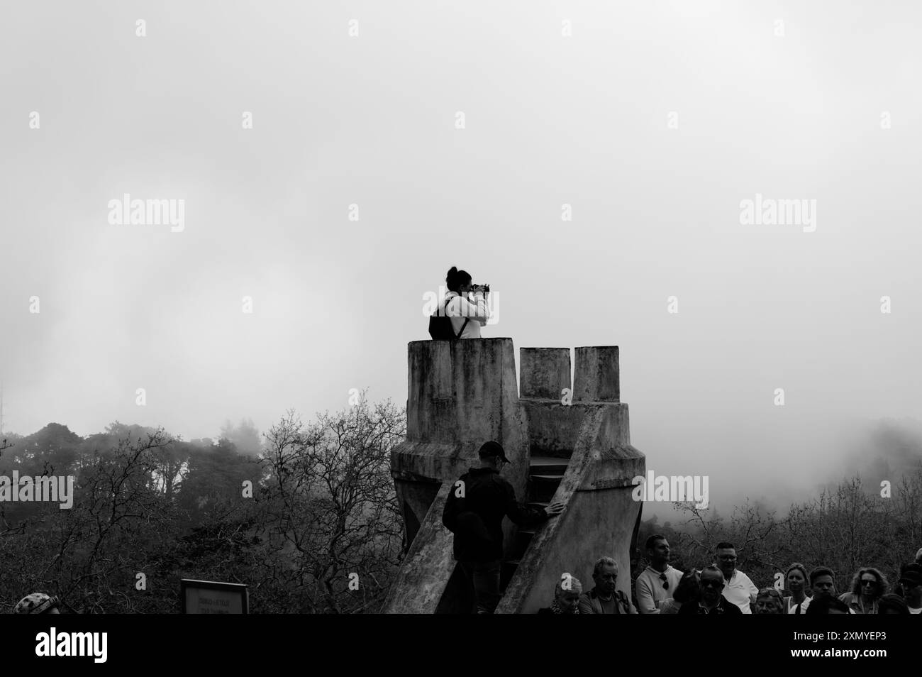 Una fotografa si trova in una piccola torre di guardia a Palazzo pena, catturando le vedute nebbiose che avvolgono l'antico sito Foto Stock