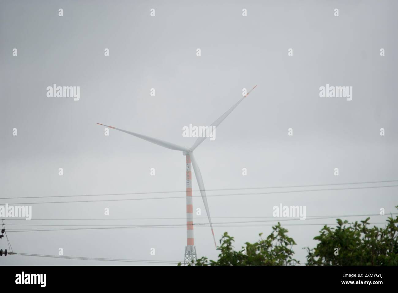 La straordinaria fotografia enfatizza la nozione di energia rinnovabile con una potente turbina eolica. Simboleggiano le lame sottili che si estendono verso il cielo Foto Stock