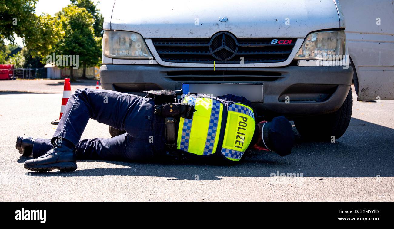 Amburgo, Germania. 30 luglio 2024. SI PREGA DI PIX IL CARTELLO DI IDENTIFICAZIONE - Un agente di polizia controlla un'auto per verificare la presenza di difetti tecnici nel distretto di Bahrenfeld. Durante un controllo su larga scala, la polizia ha verificato la conformità alle norme sulla sicurezza stradale. Credito: Daniel Bockwoldt/dpa - ATTENZIONE: Le targhe sono state pixellate per motivi legali/dpa/Alamy Live News Foto Stock