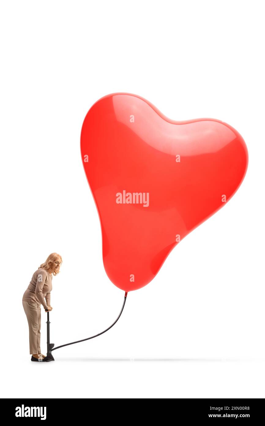 Donna che usa un tiralatte manuale e pompa un palloncino a forma di cuore isolato su sfondo bianco Foto Stock