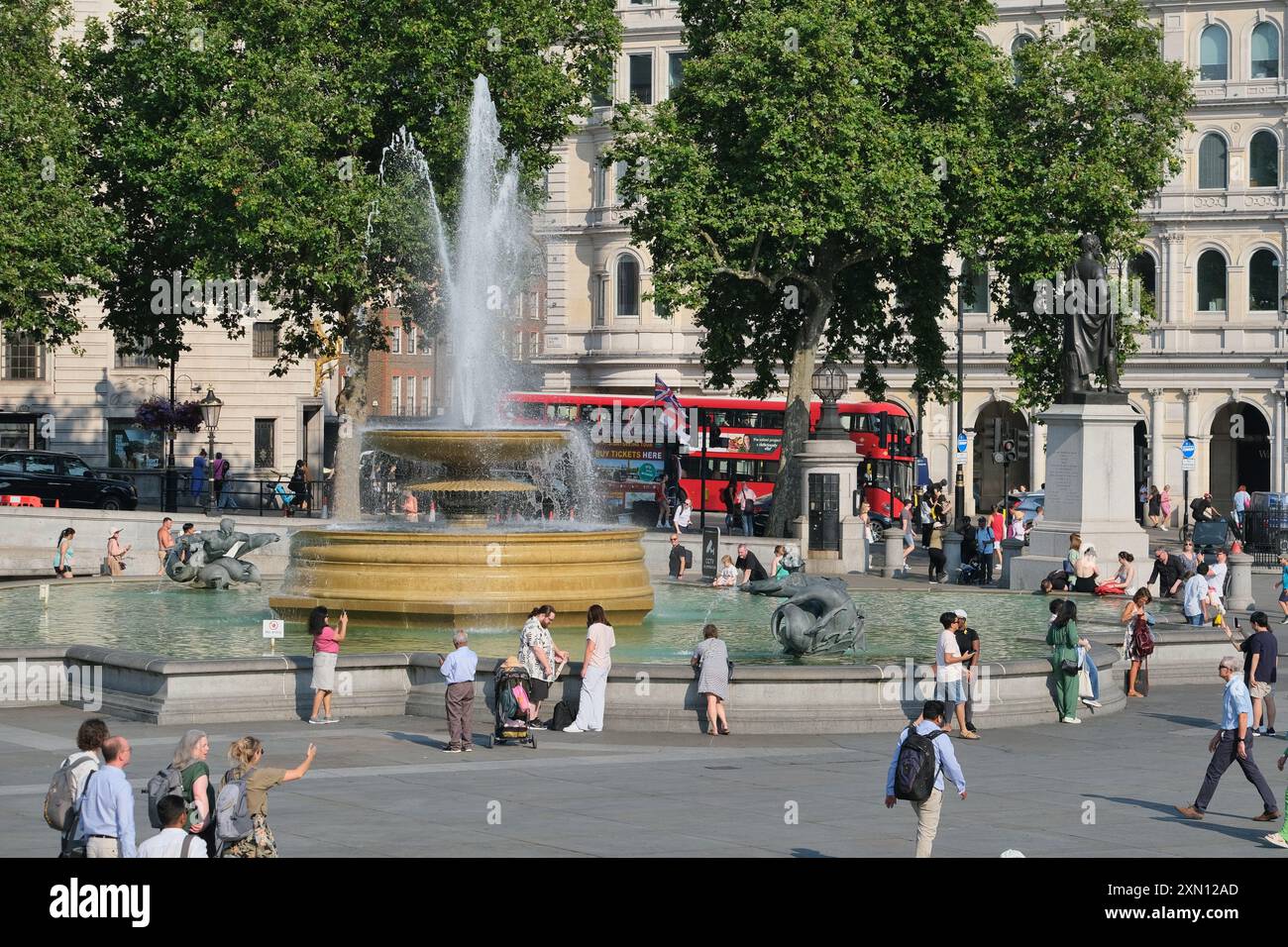 Londra, Regno Unito, 30 luglio 2024. I visitatori di Trafalgar Square si rinfrescano accanto alle fontane, poiché il Met Office registra 32 gradi celsius a Heathrow e ai Kew Gardens, rendendolo il giorno più caldo dell'anno finora. Credito: Fotografia dell'undicesima ora/Alamy Live News Foto Stock