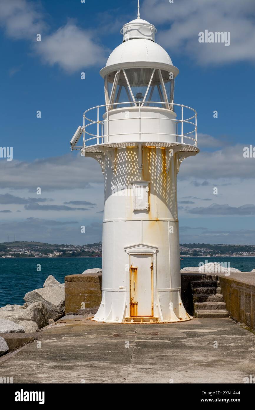 Il faro bianco e il faro alla fine del molo nella cittadina balneare di Brixham Foto Stock