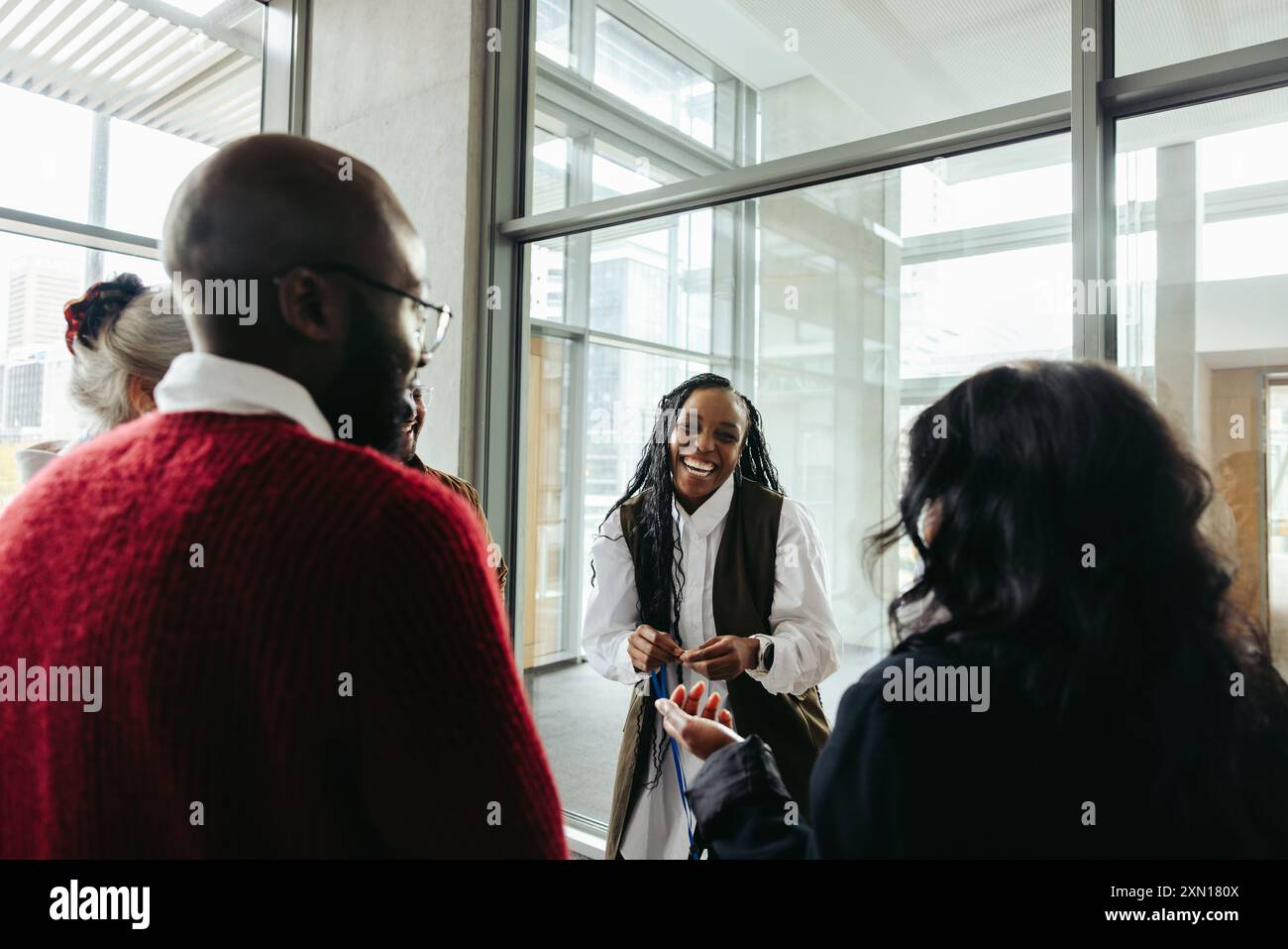 Donna nera felice e di successo che interagisce con i colleghi in una riunione aziendale, mostrando il lavoro di squadra e la leadership. Foto Stock