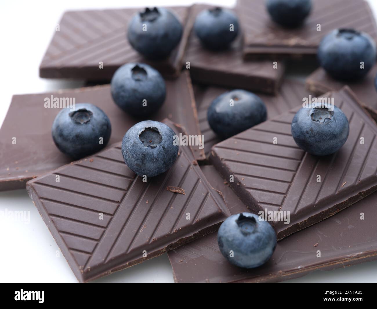 Cioccolato fondente rotto e mirtilli freschi maturi. Primo piano. Foto Stock