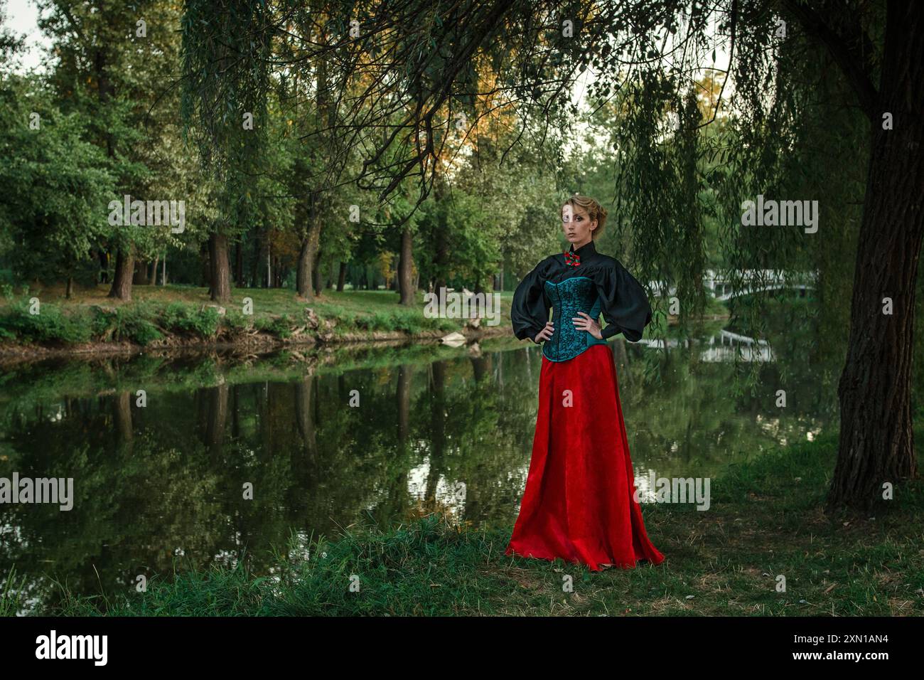 Modello ragazza con capelli bianchi in abito retrò con volant in un parco verde Foto Stock