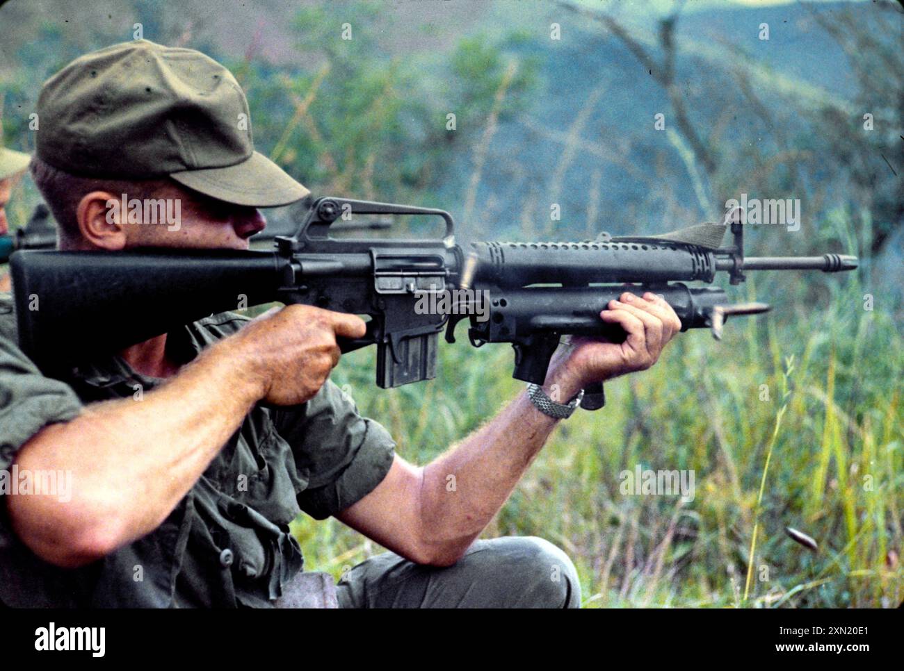 Il soldato dell'esercito americano spara il suo XM16E1 con il lanciagranate XM148 durante una missione nella provincia di Quang Ngai, Repubblica del Vietnam Foto Stock