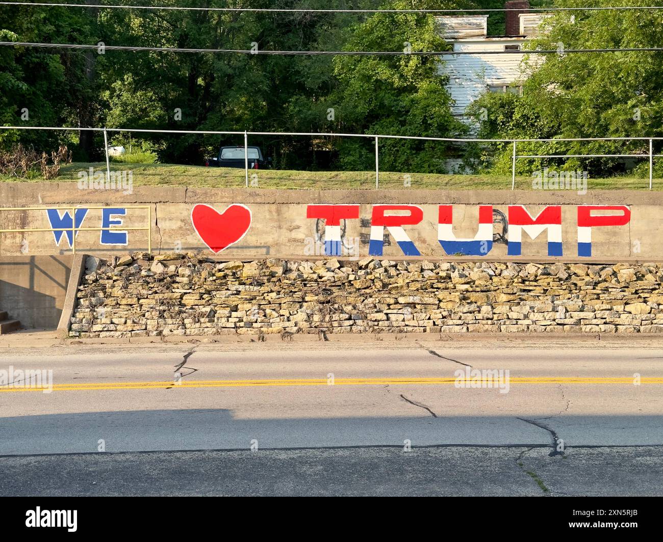 We Love Trump dipinto in rosso, bianco e blu su un muro di cemento da un'autostrada all'aperto. Foto Stock