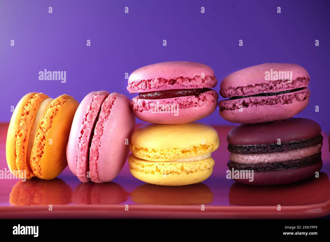 Gamma di macaron disponibili nelle sfumature di giallo e rosa, trame e colori di dolci macaron francesi a base di meringa, immagini a profondità di campo Foto Stock
