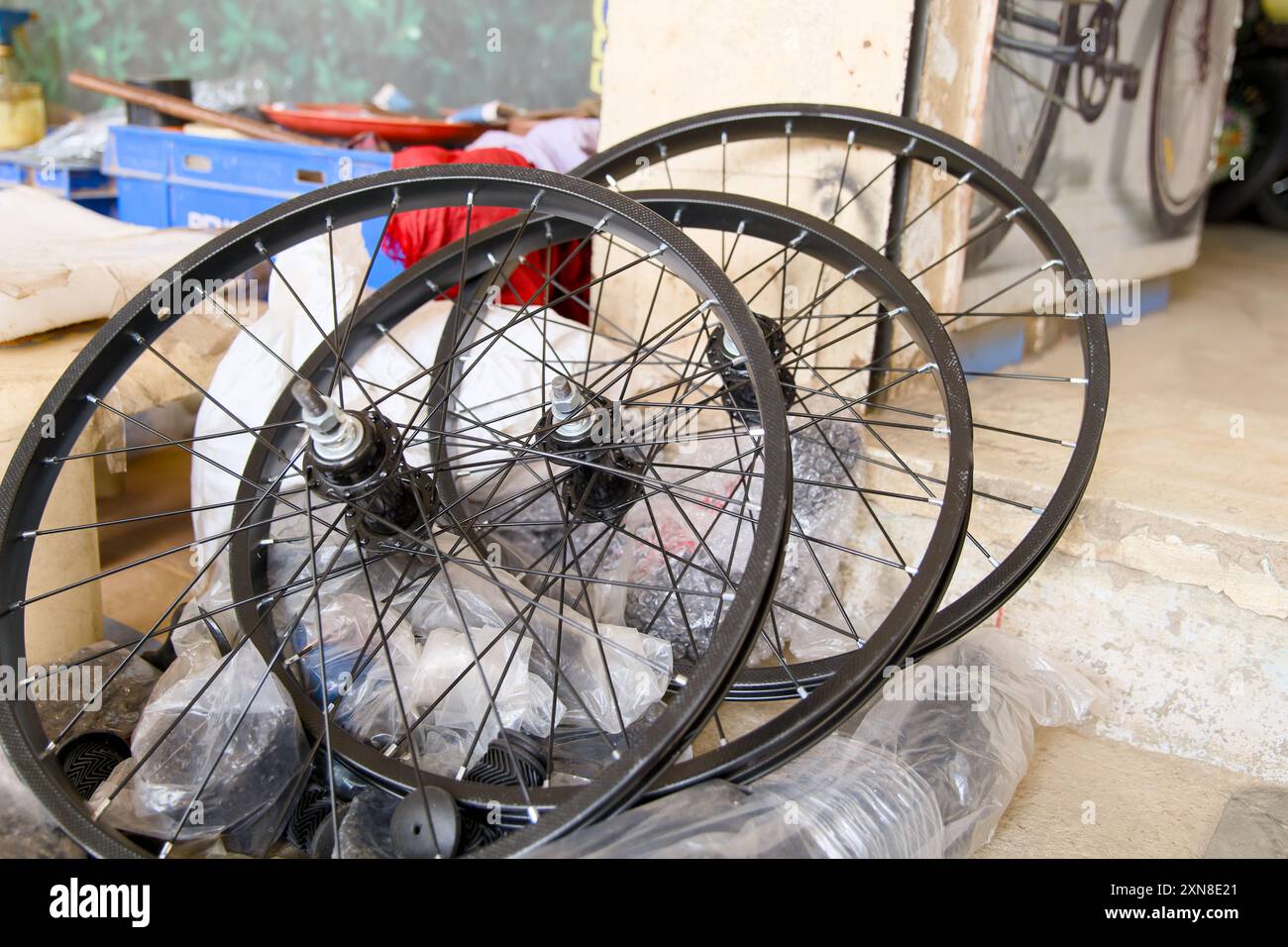 Ruote per biciclette nuove e brillanti, raggi brillanti, in attesa di montaggio. Perfetto per escursioni in bicicletta, trasporti o riparazioni. Foto Stock