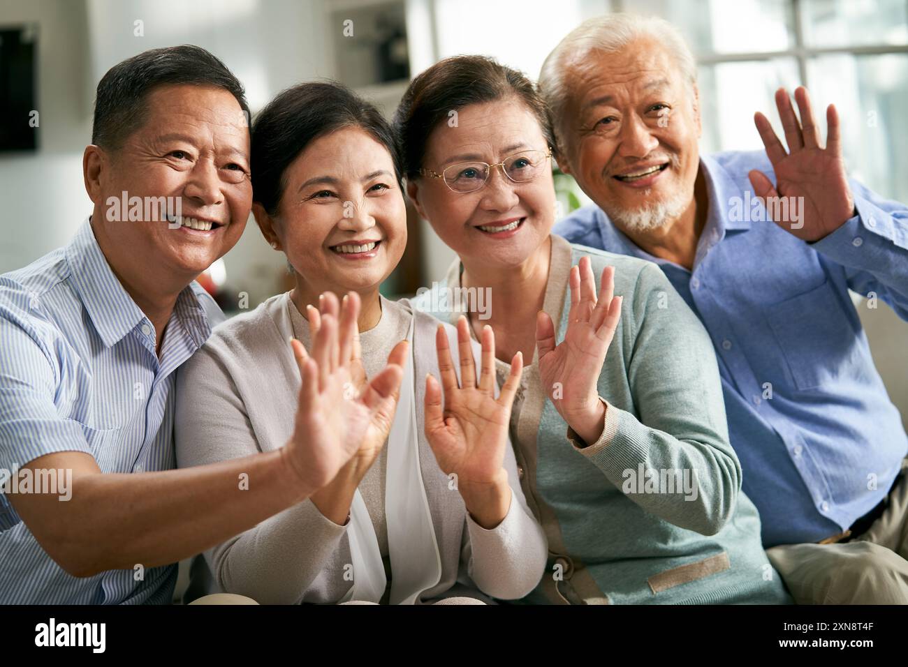 gruppo di persone asiatiche senior felici due coppie che saltano le mani e salutano amici o familiari durante la videochat Foto Stock