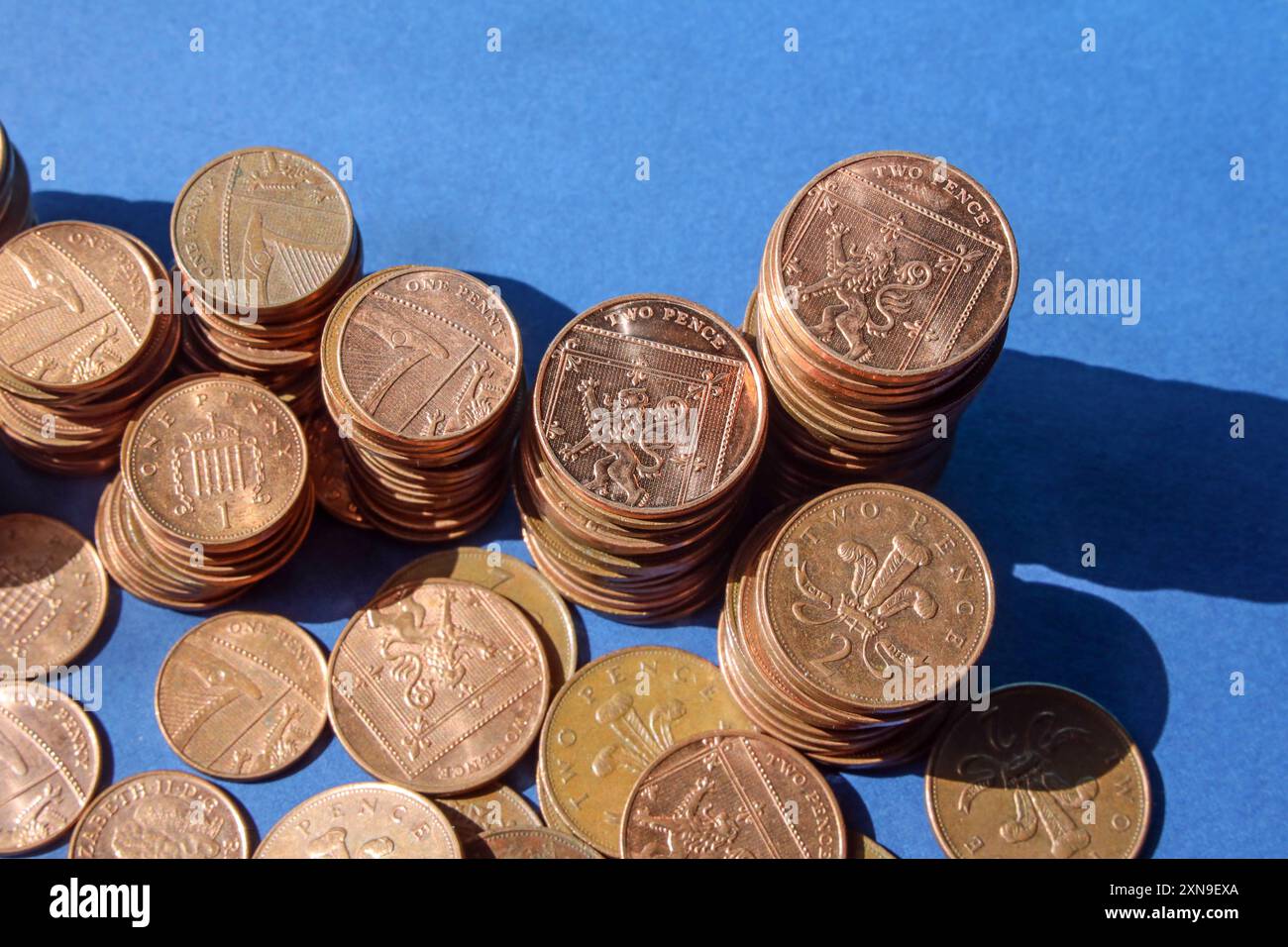 Monete inglesi basse su sfondo blu con forte illuminazione direzionale, monete da 1p, 2p incluse . Per molti anni ci sono state speculazioni in merito Foto Stock