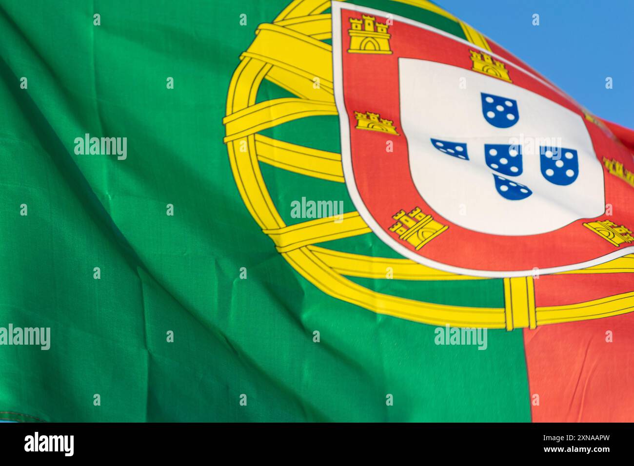 Foto ravvicinate della bandiera nazionale della Repubblica portoghese su sfondo blu Foto Stock